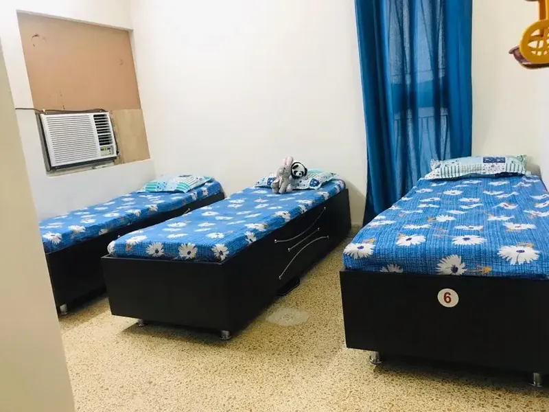 Comfortable AC 3 Sharing Girls PG Room with Blue Bedsheets in Ahmedabad
