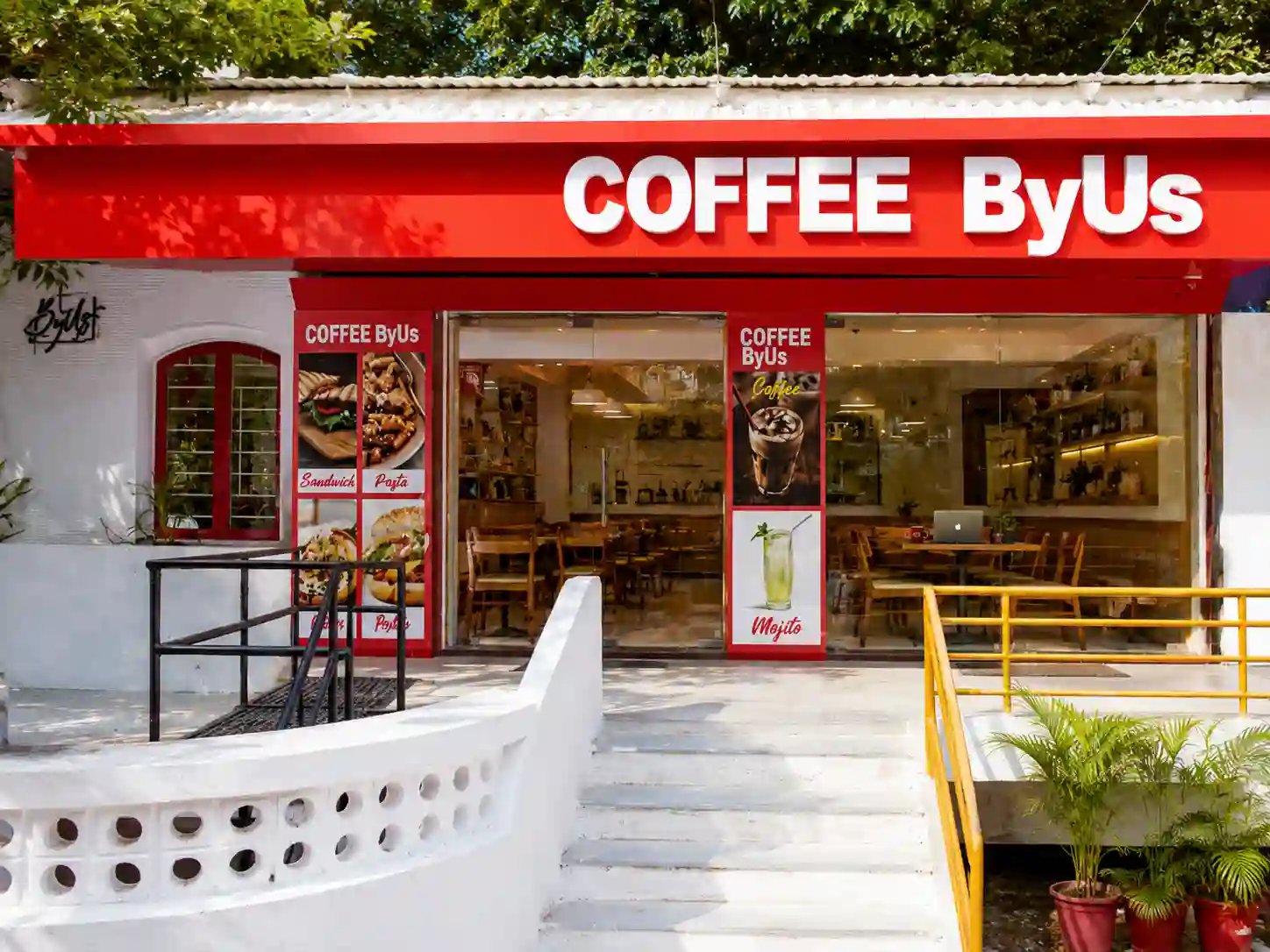 Red front storefront and study-friendly window seats of COFFEE ByUs Navrangpura Ahmedabad